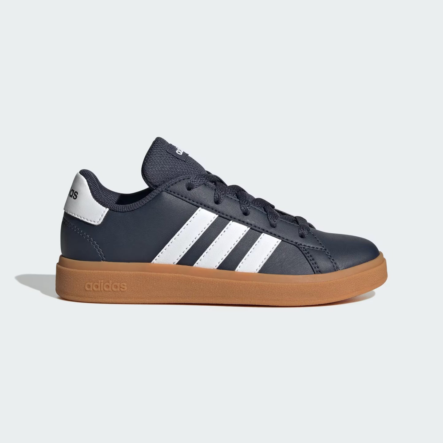 Black sneaker with white stripes and brown sole on a light gray background