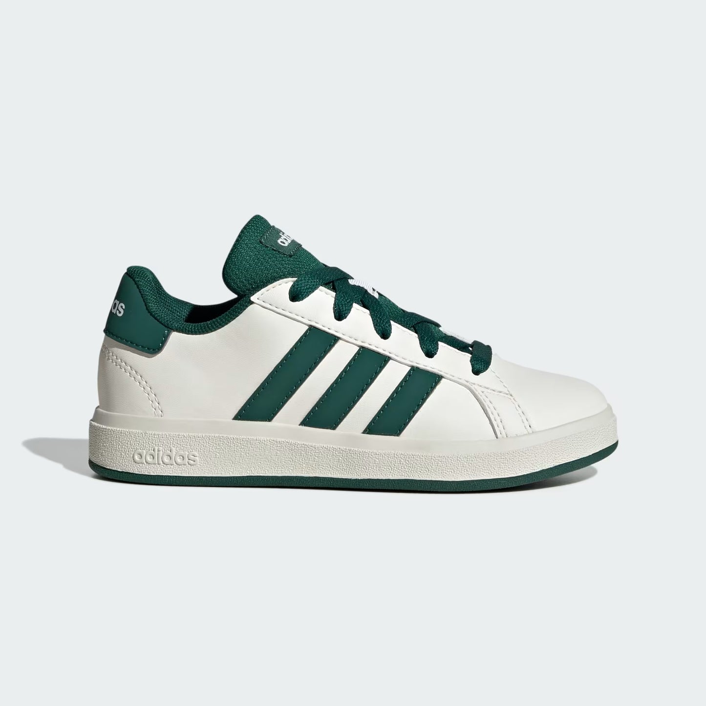 White sneaker with green stripes and accents on a light gray background