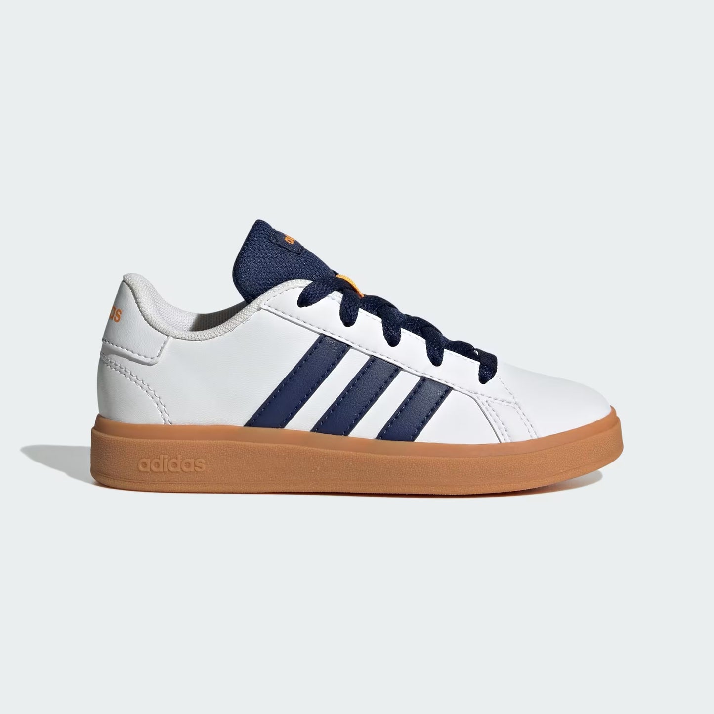 White sneaker with blue stripes and brown sole on a light gray background