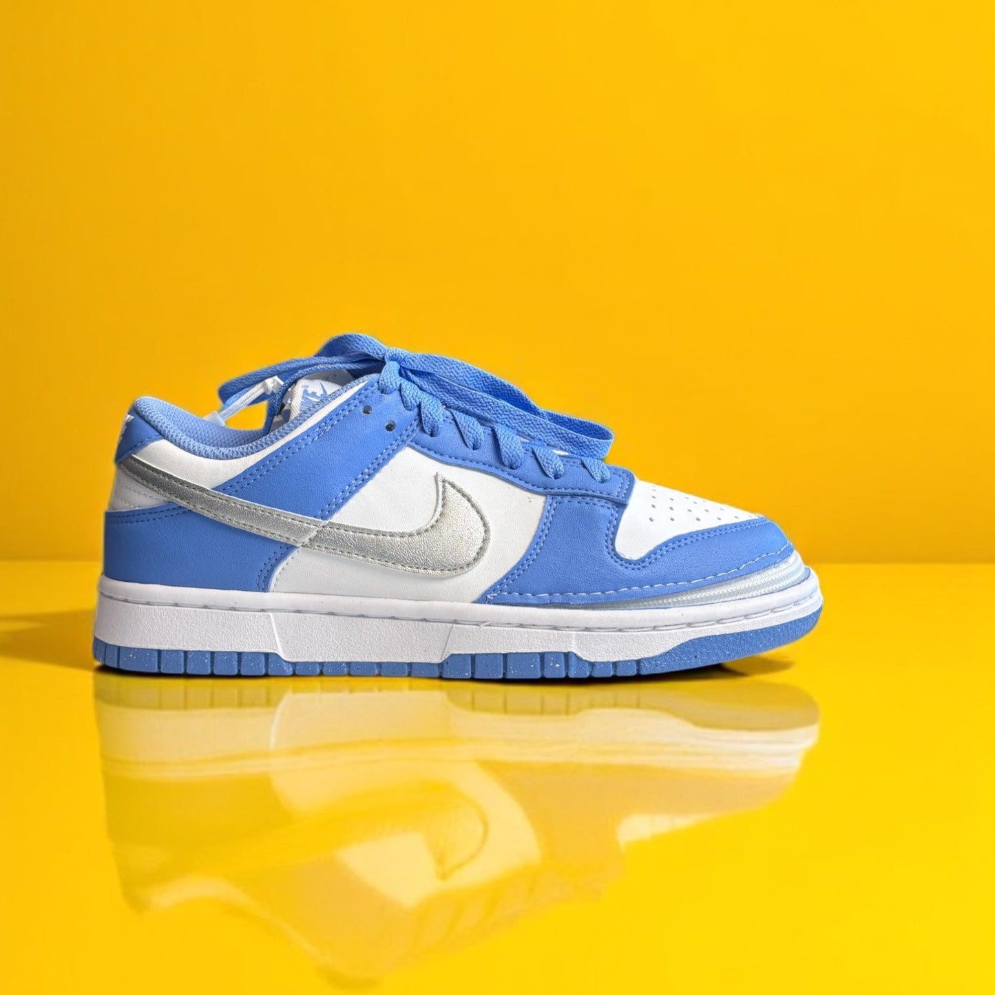 Blue and white shoe with a zipper on yellow background. The shoe is zipped shut