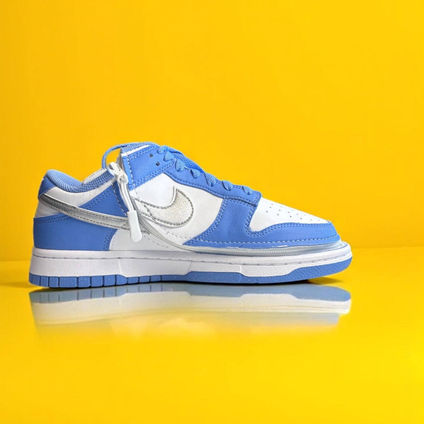 Blue and white shoe with a zipper on yellow background. The shoe is zipped shut