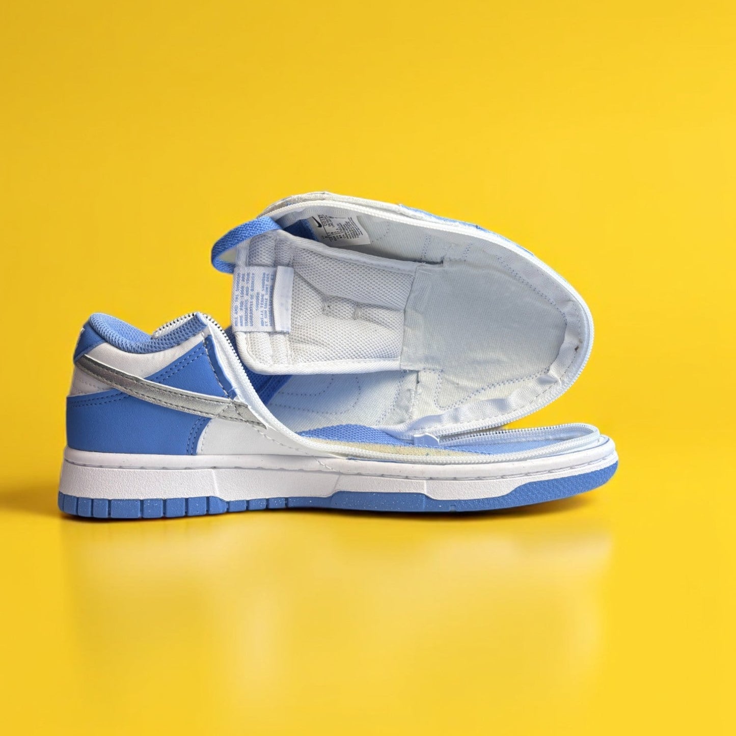 Blue and white shoe with a zipper on yellow background. The shoe is fully open