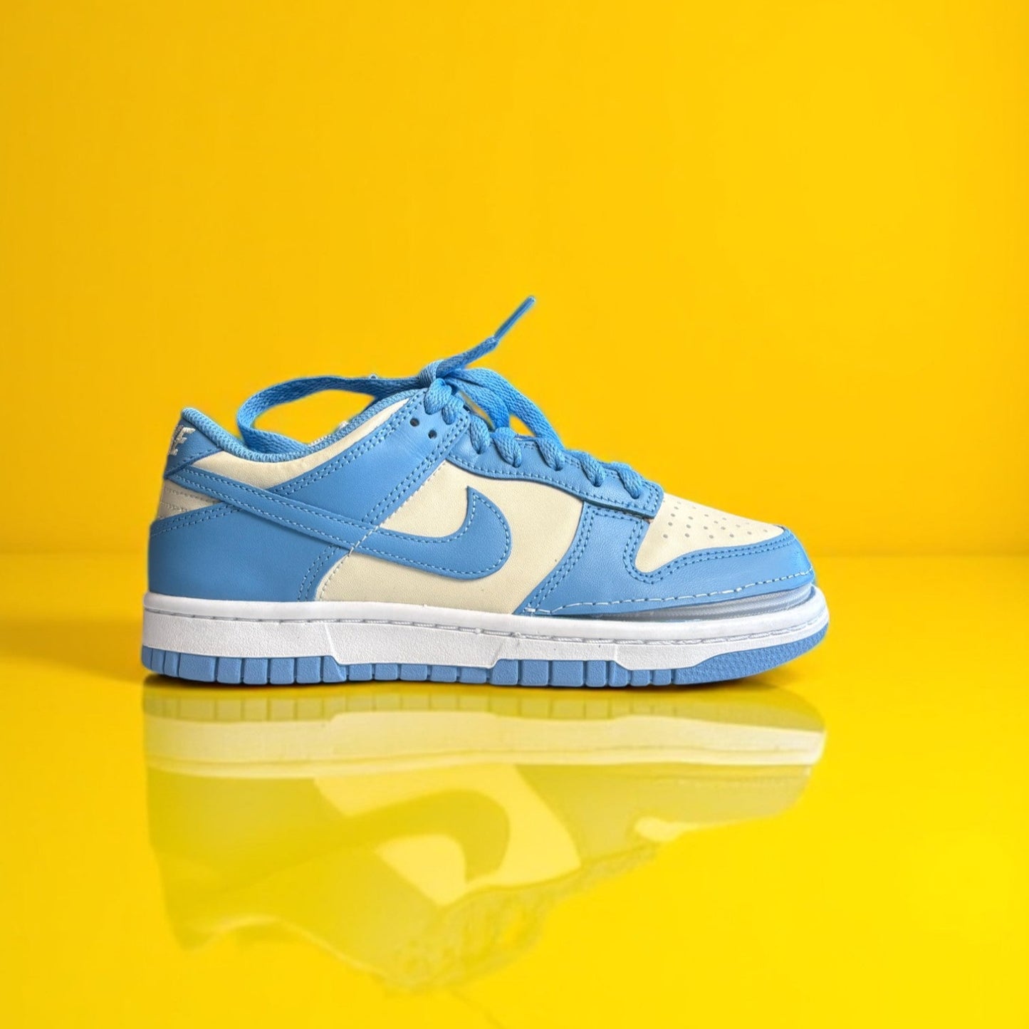 A pair of Kids' shoes with a zipper, primarily in blue and white colors on a yellow background. The shoe is zipped shut
