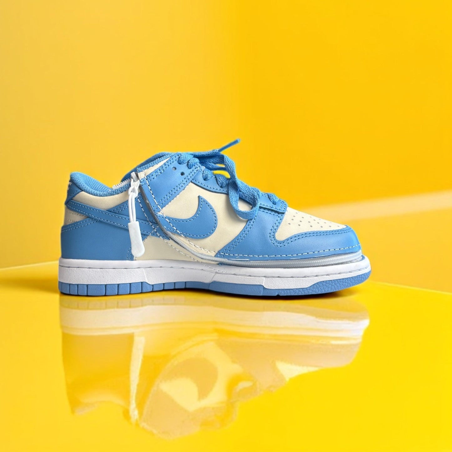 A pair of Kids' shoes with a zipper, primarily in blue and white colors on a yellow background. The shoe is zipped shut