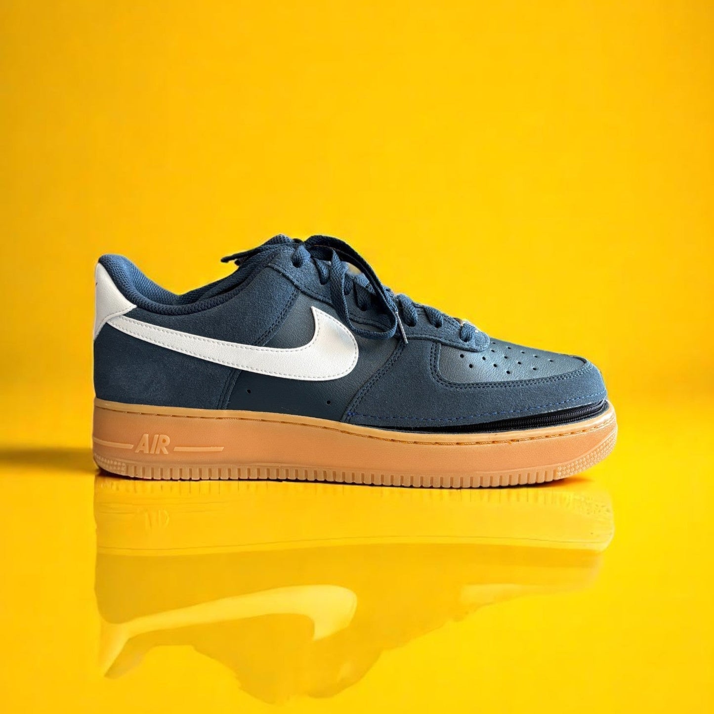 Navy blue shoe with a zipper on a yellow background. The zipper is visible