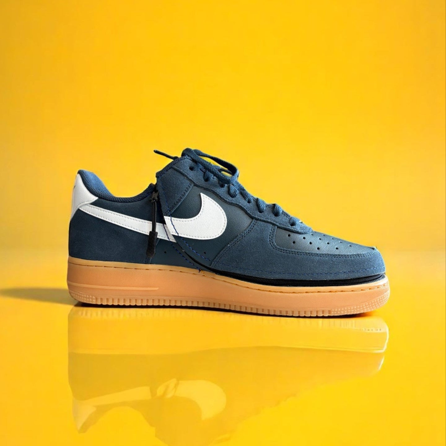 Navy blue shoe with a zipper on a yellow background. The shoe is zipped shut