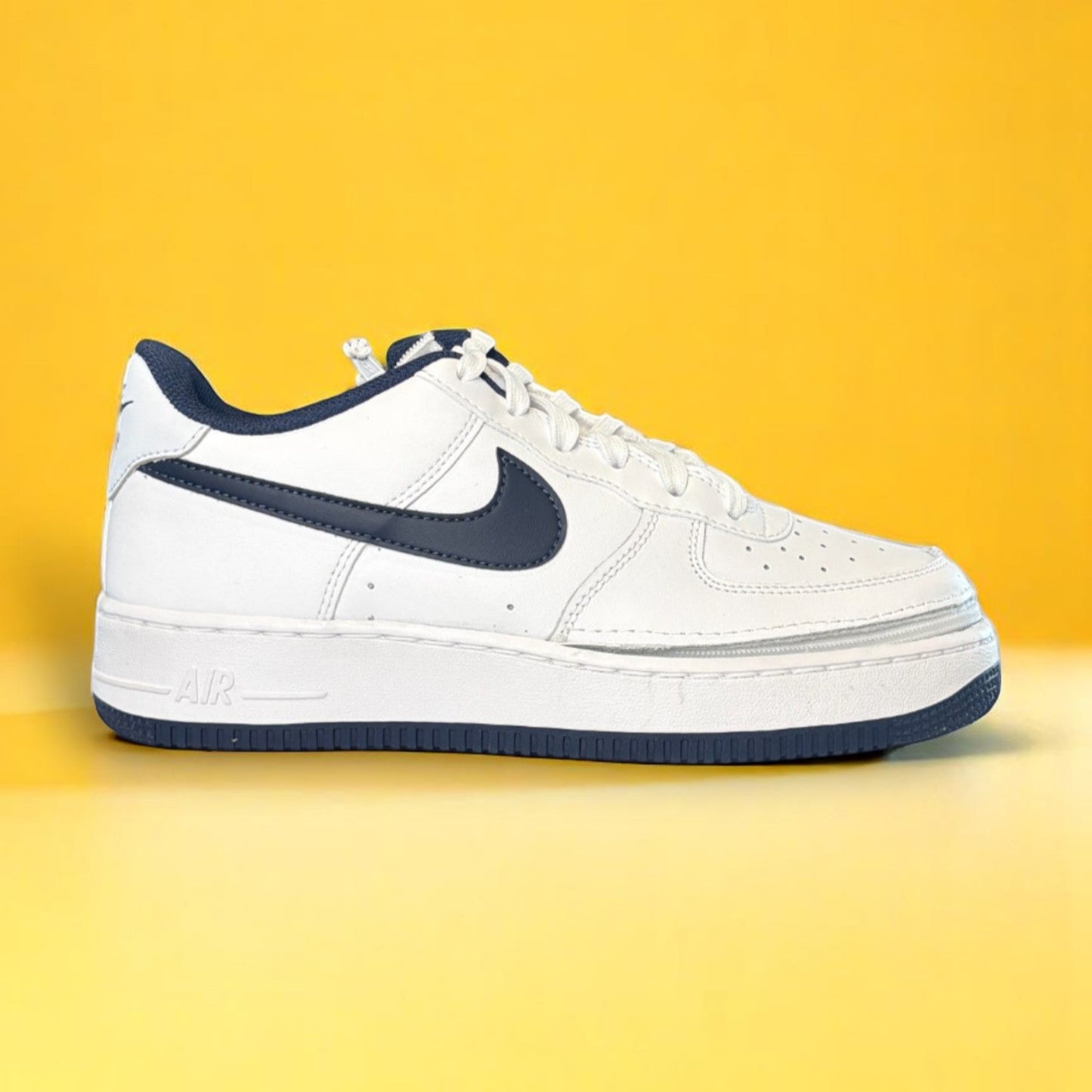 Kids white and navy shoe with a zipper on yellow background. The shoe is zipped shut