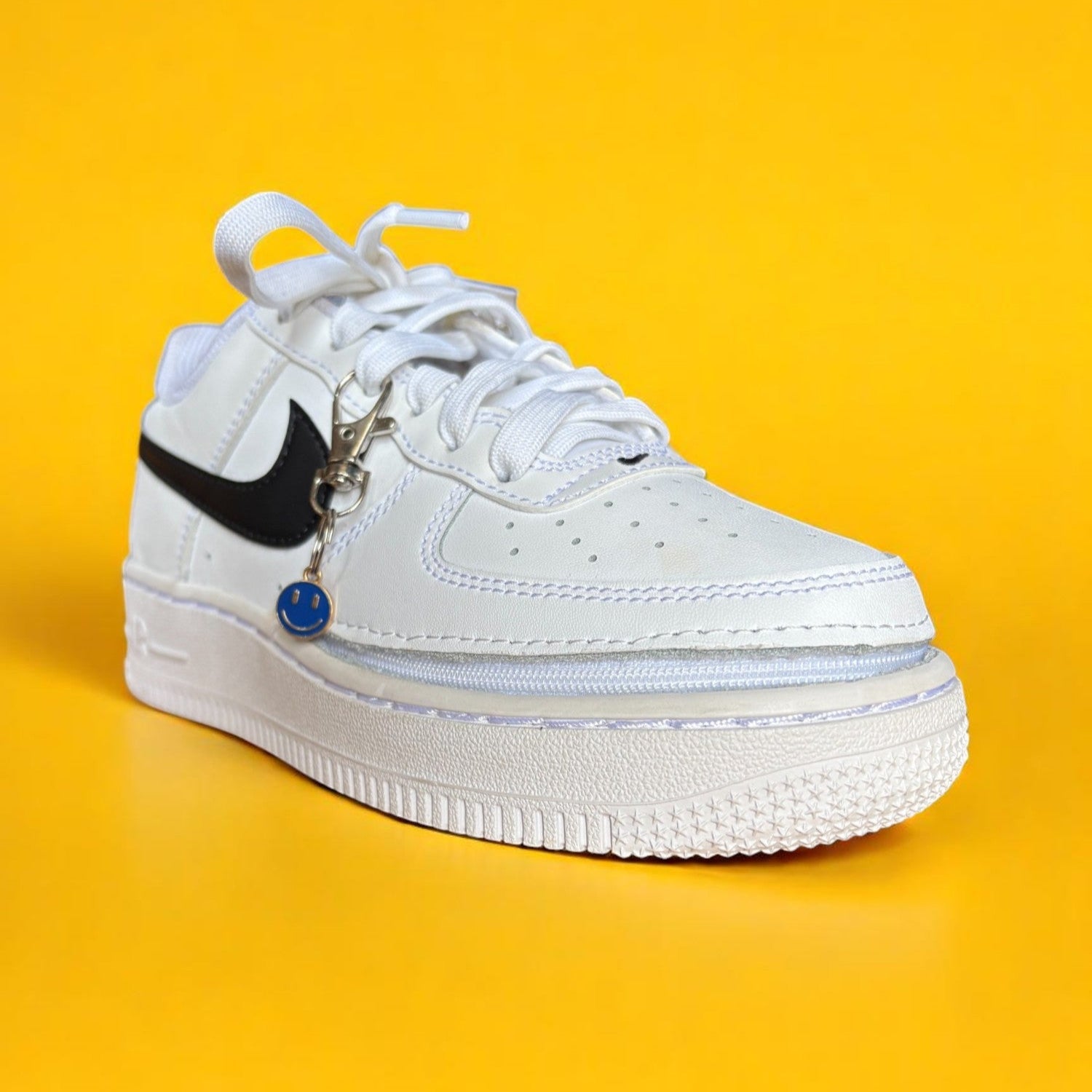 White sneaker with black accent on a yellow background