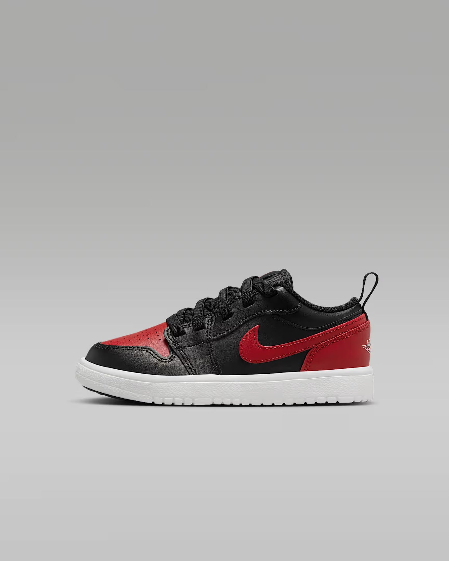 Black and red sneaker with a visible brand logo on a gray background
