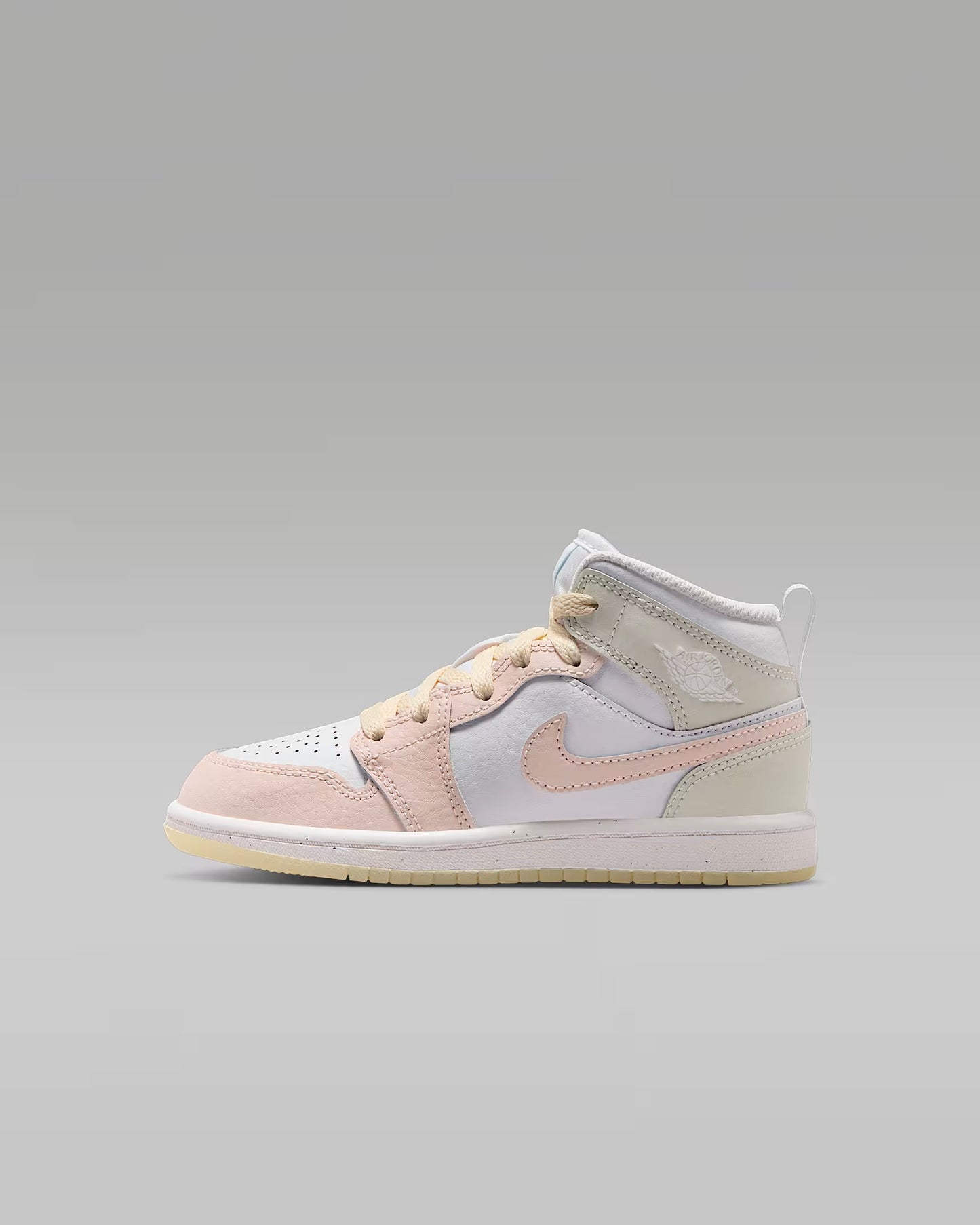 White and pink mid top sneaker on a gray background