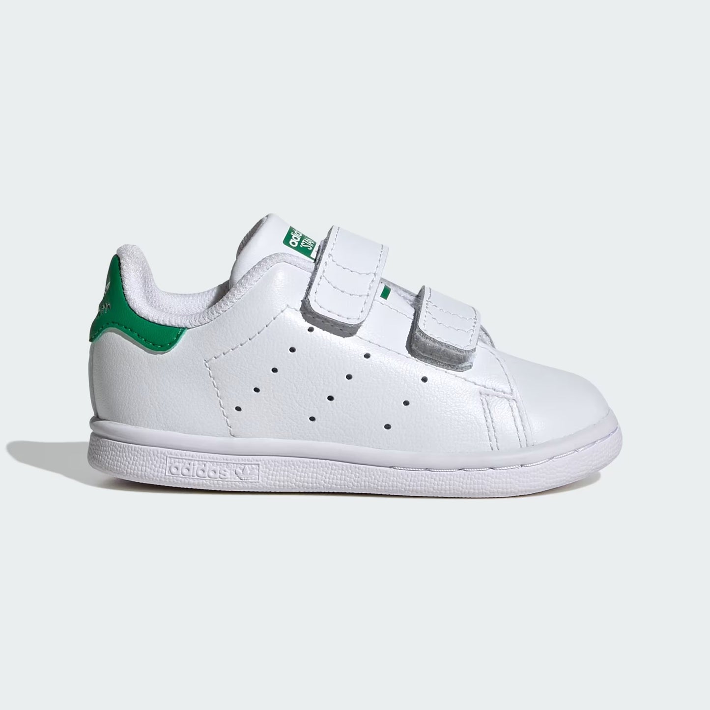 White sneaker with green accents on a light gray background