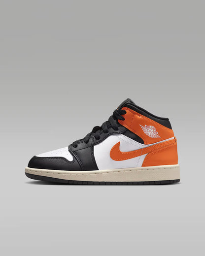 Black, orange, and white sneaker on a gray background