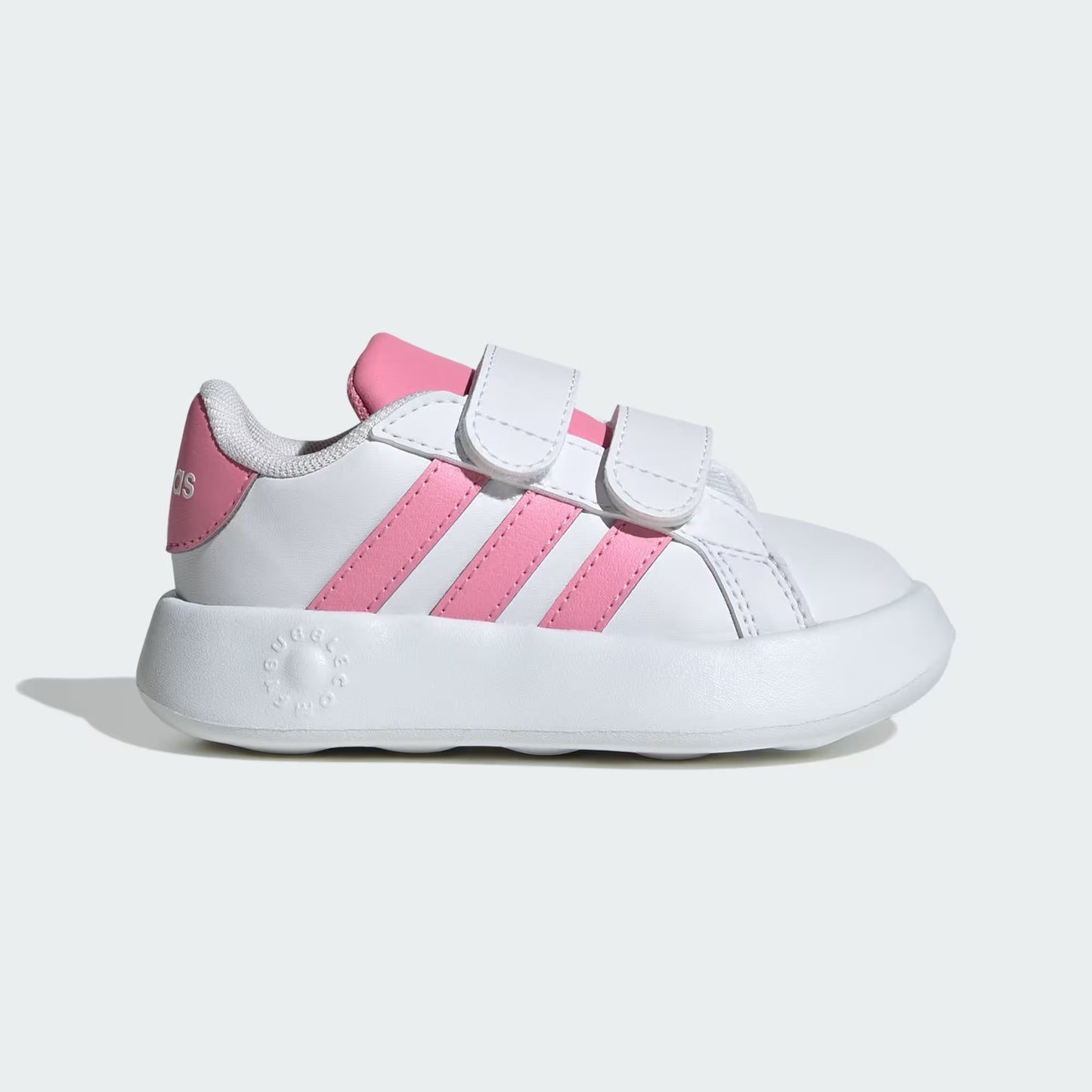 White and pink children's sneakers on a light gray background