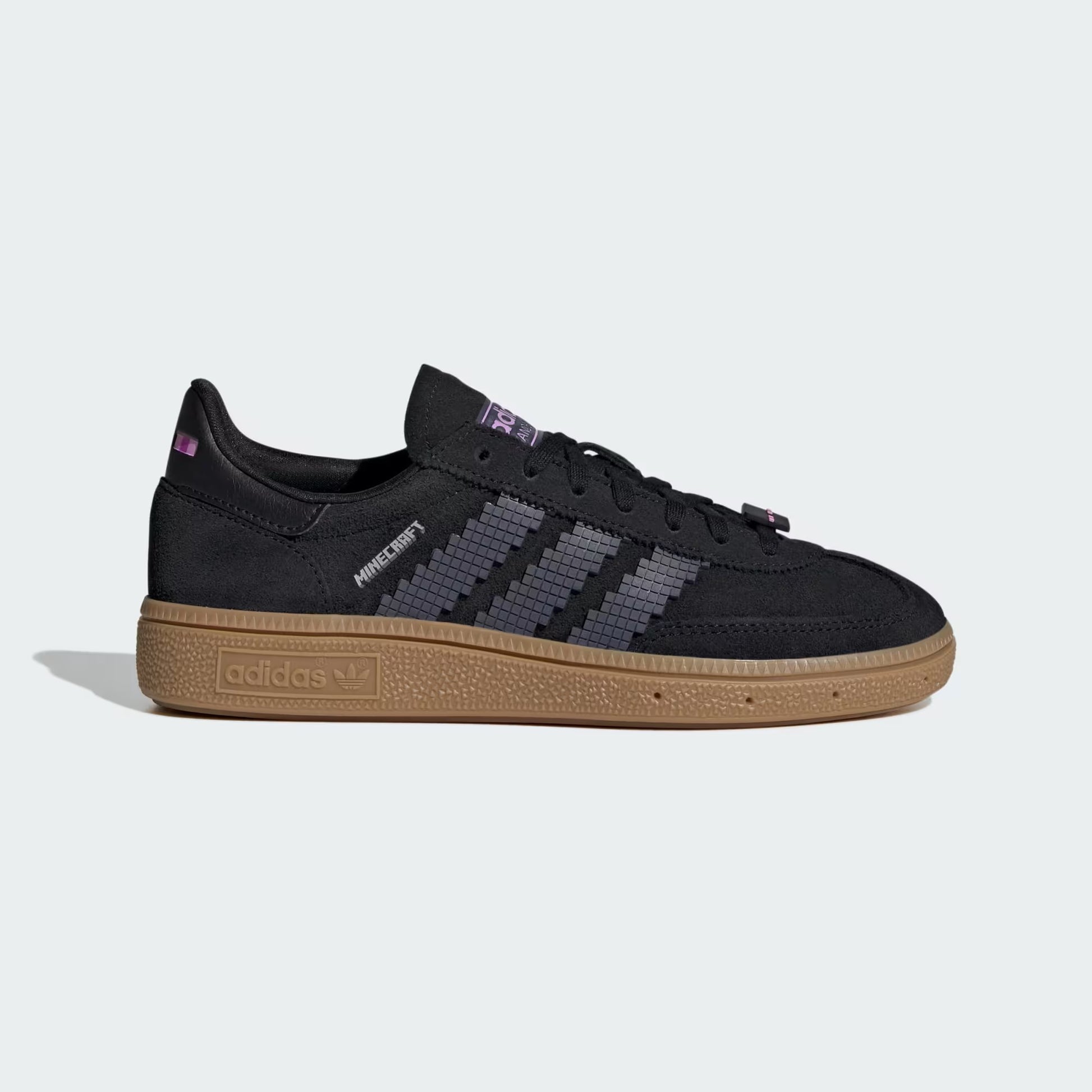 Black sneaker with brown sole on a light gray background