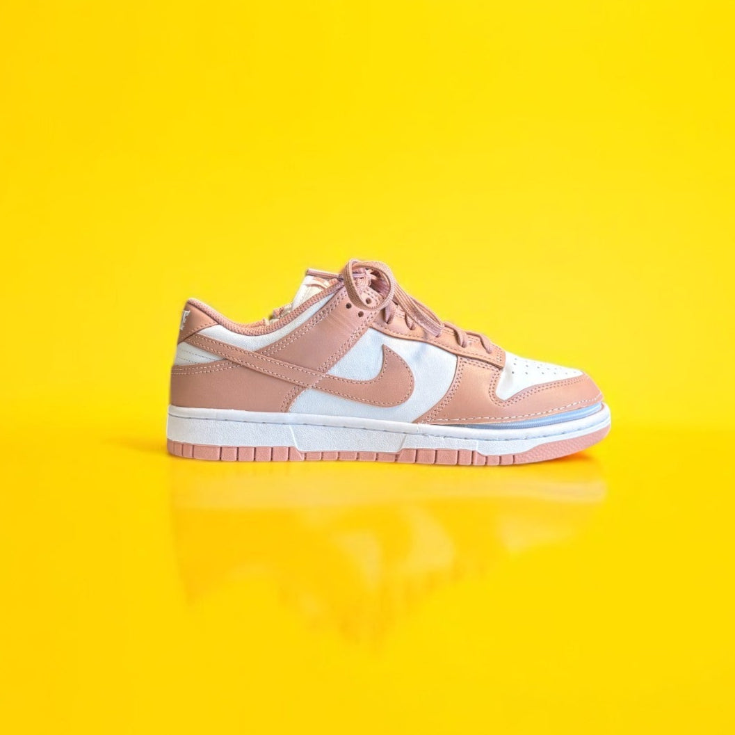 Pink sneaker with white swoosh logo on a yellow background