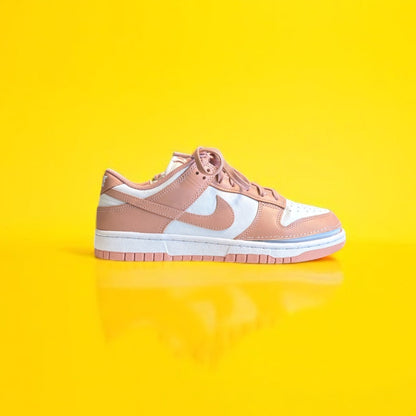 Pink sneaker with white swoosh logo on a yellow background