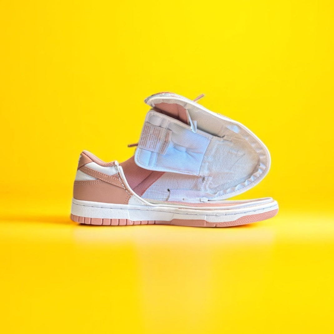 pink and White sneaker on a yellow background. The shoe is fully open 