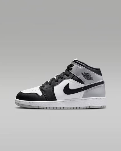 Black and white sneaker with a gray sole on a gray background