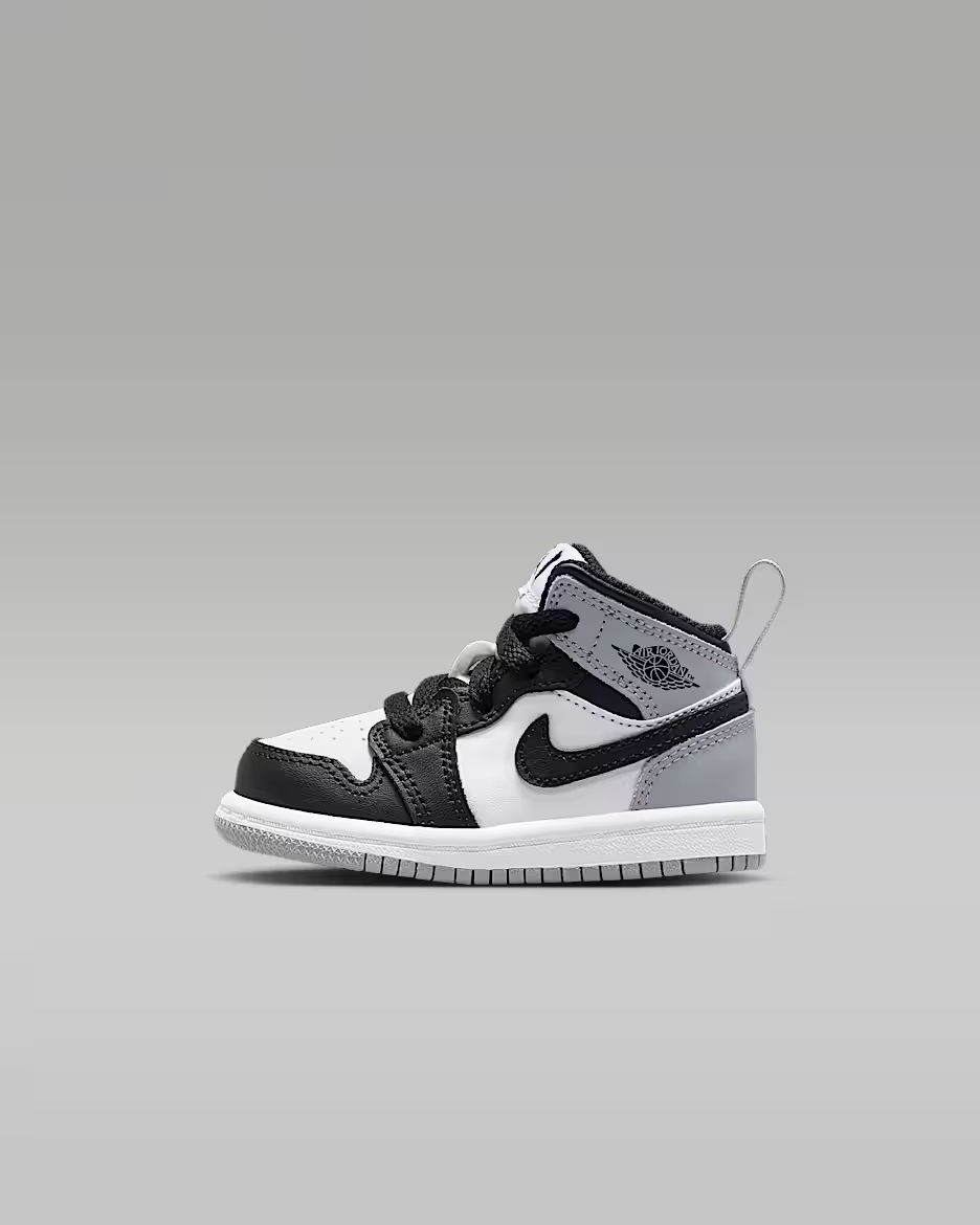 Black and white sneaker with a gray sole on a gray background